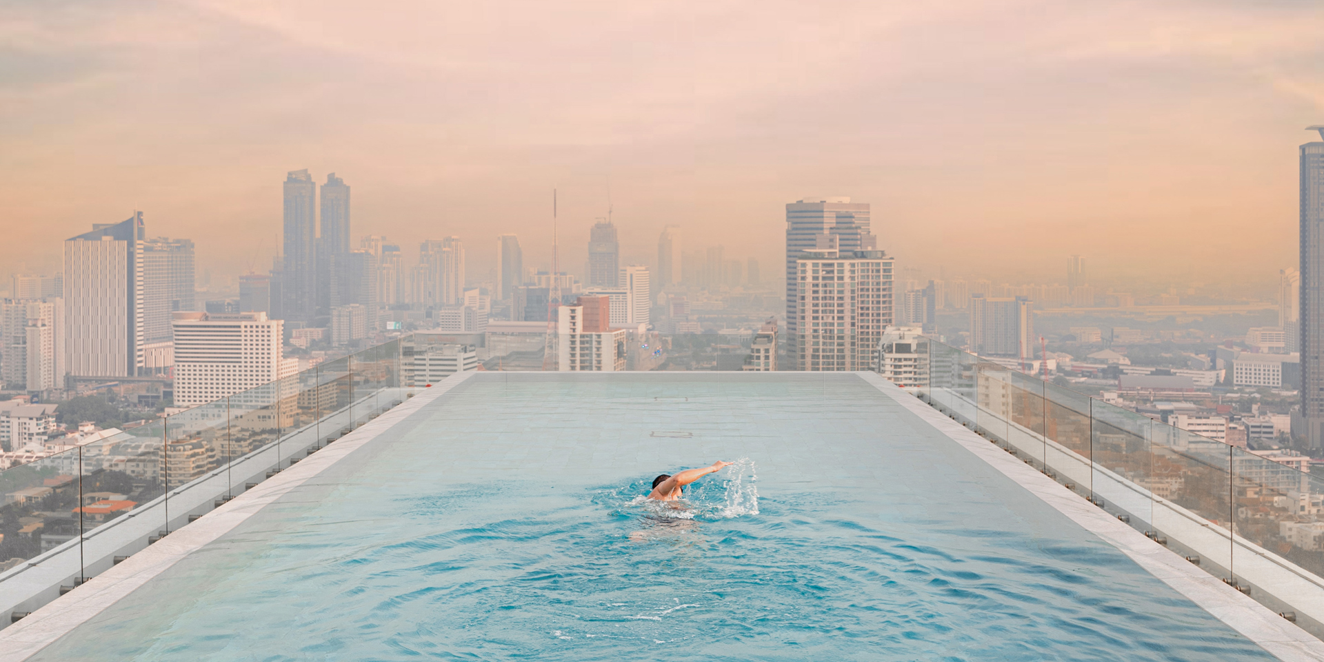 A woman in the rooftop pool at 137 Pillars Bangkok.