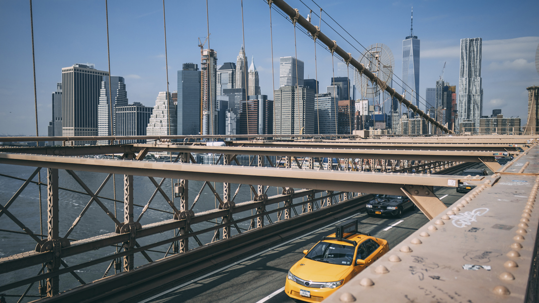 A view of New York with skyscrapers and a yellow taxi cab.