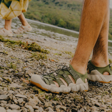 Modern hiking sandals bearing worn in a muddy environment.