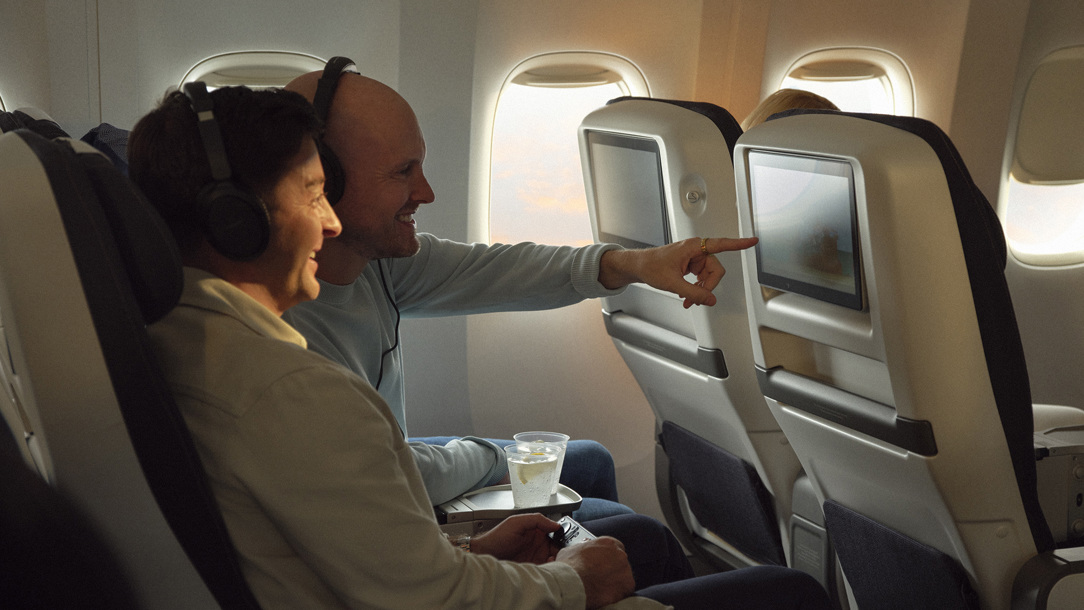 Passengers onboard a British Airways plane using the inflight entertainment.