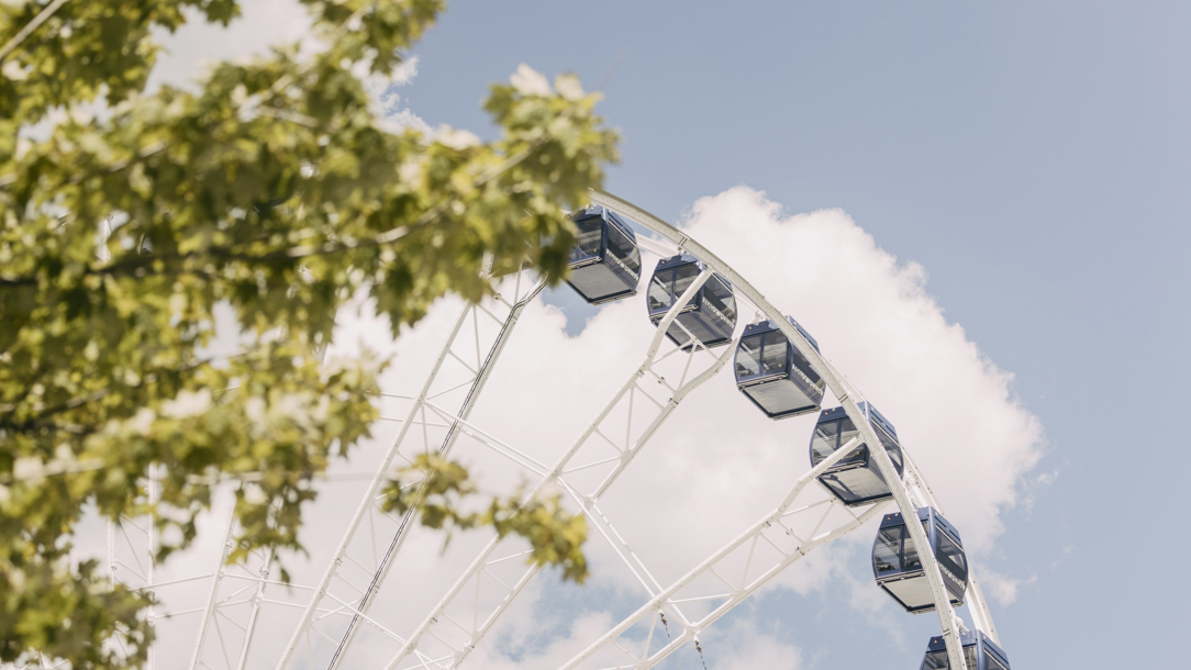 A Ferris Wheel against a cloudy sky.