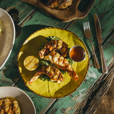 Food on a yellow plate on a blue wooden table photographed from above.