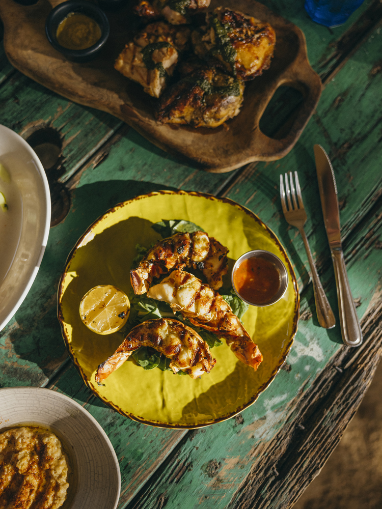 Food on a yellow plate on a blue wooden table photographed from above.