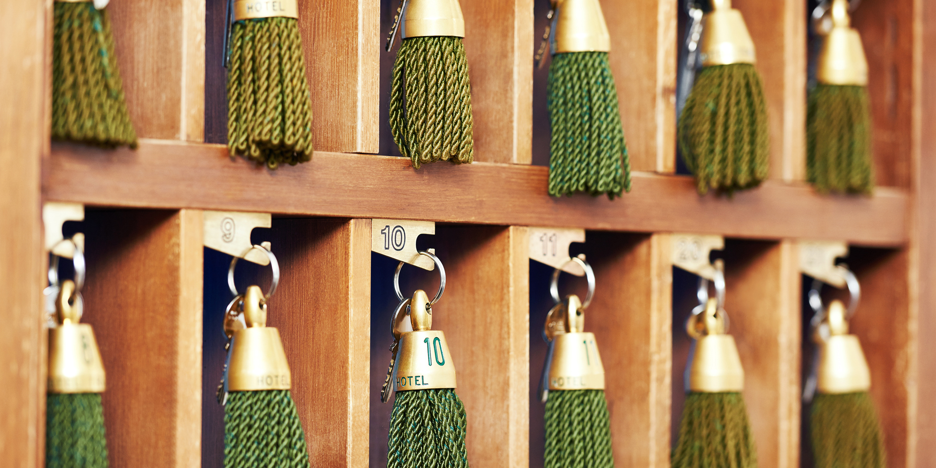 A close up of hotel keys with green tassels.