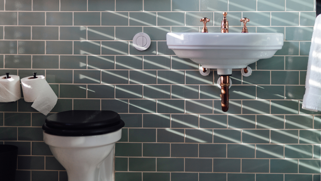 A stylish bathroom with green tiles.