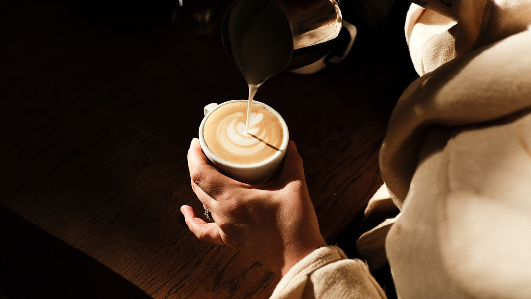 A coffee being prepared by a barista.