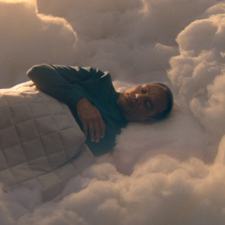 A still of a man sleeping among clouds from a British Airways advert.