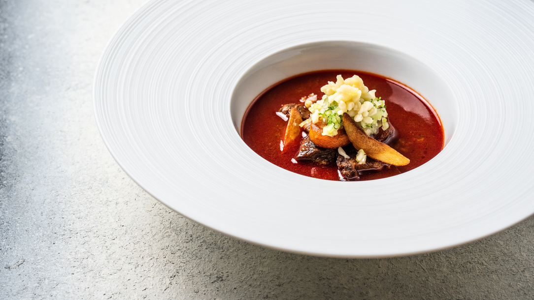 A dish of Gulyas in a large white plate.