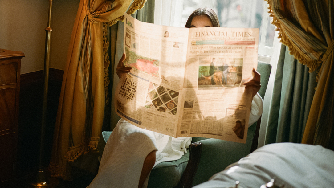 A woman reading a newspaper at the Lanesborough Hotel in London.