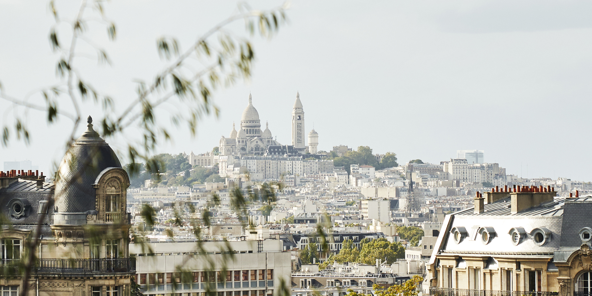 A view towards the Montmartre in Paris seen through trees.