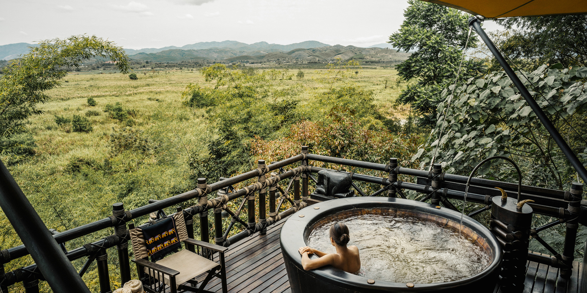 A woman in an outdoor bath at the Four Seasons Golden Triangle.