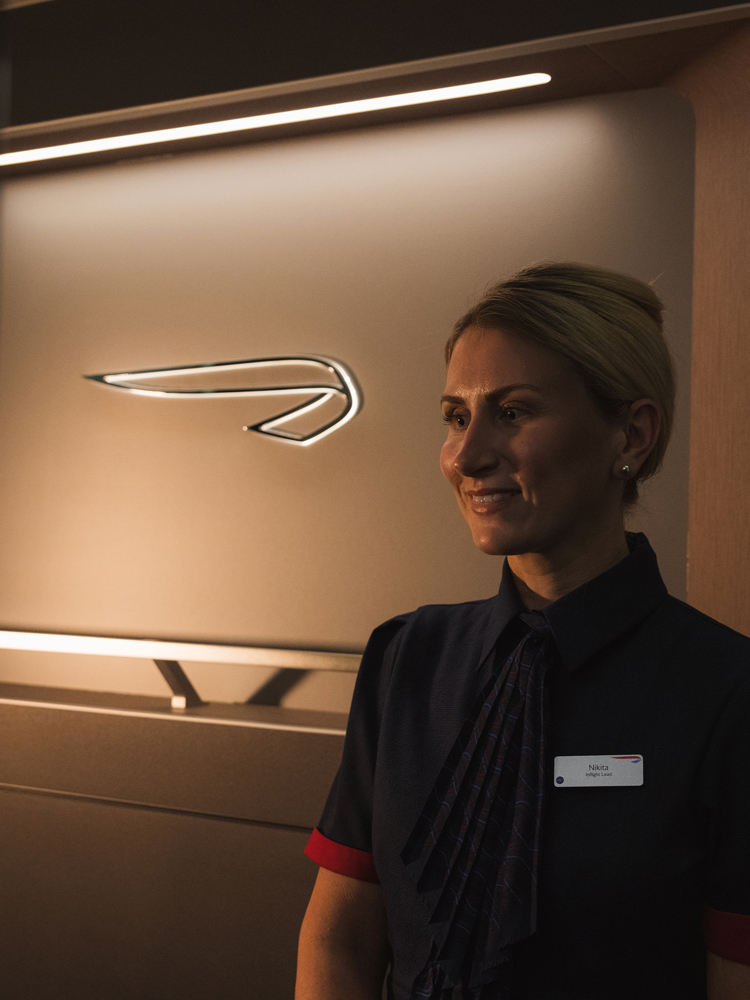 A smiling British Airways colleague in Club.