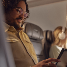 A traveller on a British Airways flight using his tablet computer.