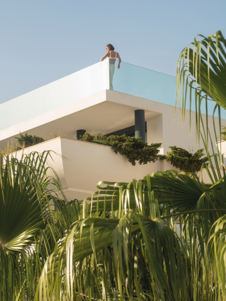 Looking up at a woman on the roof terrace of the SHA Alicante resort.