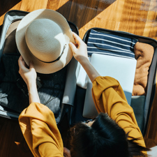 Overhead view of a woman packing a suit case.