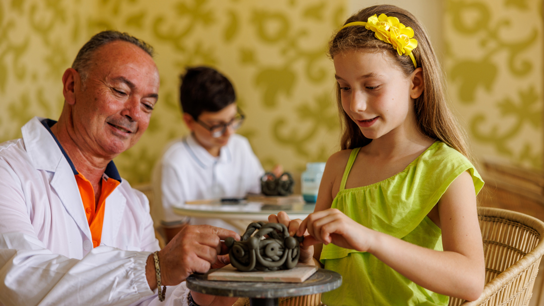 A member of staff at the Verdura Resort with a young girl.