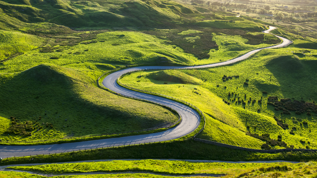 A winding road in sunny countryside.