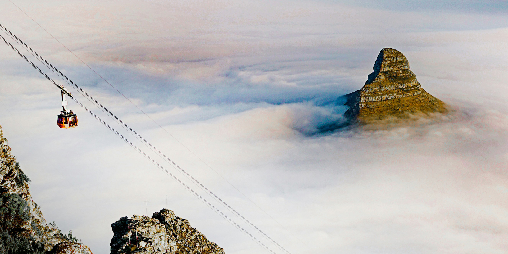 A cable car and a mountain surrounded by clouds